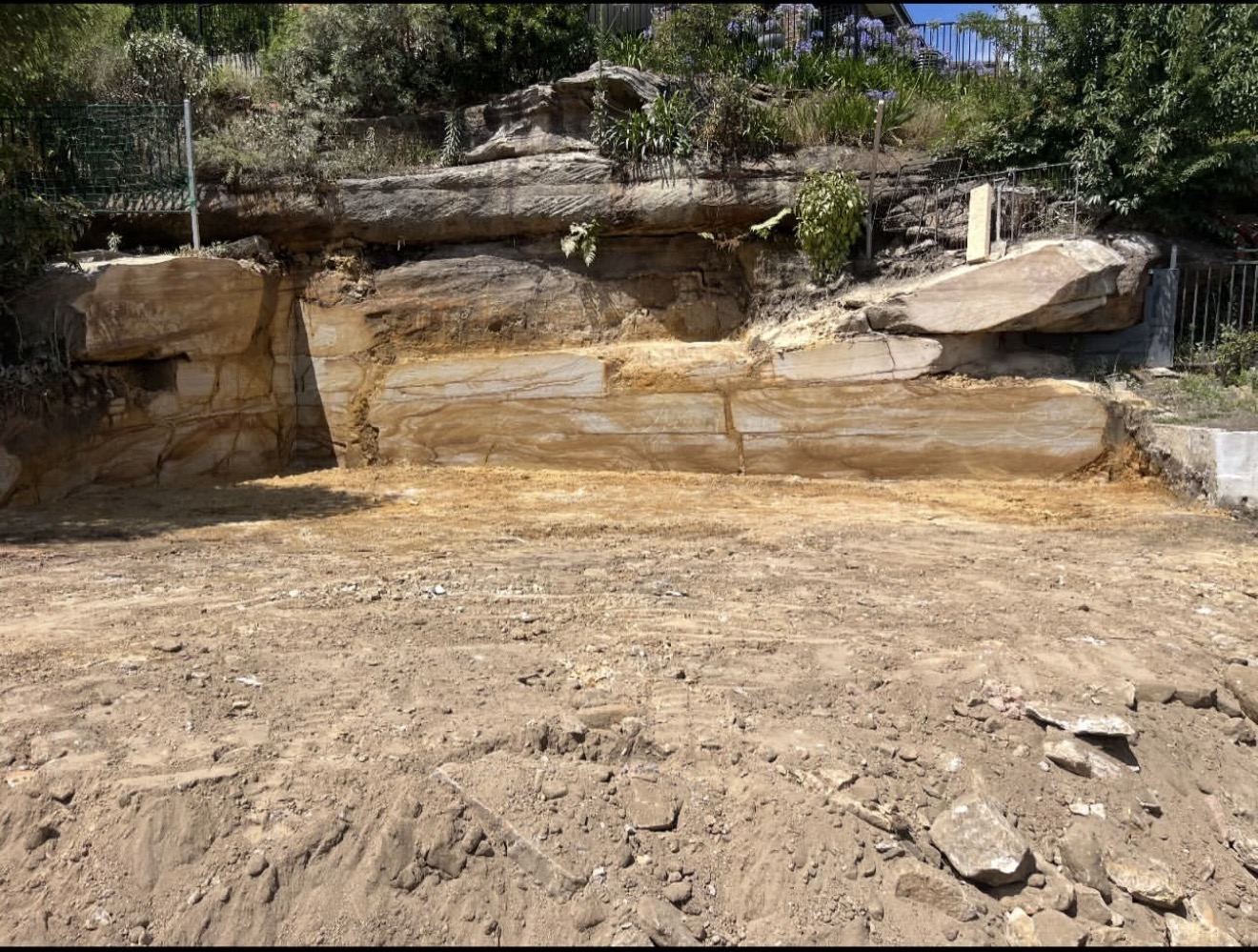Sandstone sawn into a clean vertical face with level ground